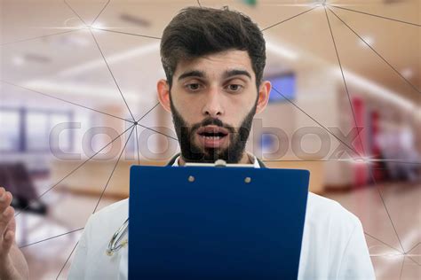 Male Doctor Standing With Folder With Shocked Expression In Hospital Stock Image Colourbox