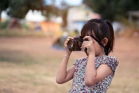Asian Little Child Girl Holding Film Camera And Taking Photo Stock