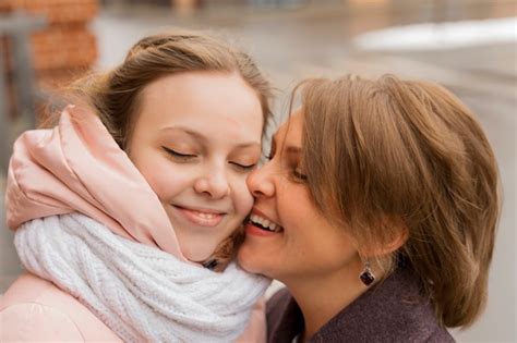 Premium Photo Mature Mother Hugs And Kisses Her Adult Daughter On The Forehead