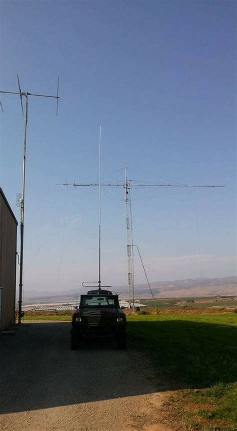 a truck parked in front of a building with two antennas on it s roof