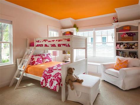 Adorable pink and orange shared girls' bedroom equipped windows flanking a white beadboard bunk bed dressed in orange and pink bedding accented with matching shams complimenting an orange painted ceiling. Pink and Orange Girls Bedroom with Orange Ceiling ...