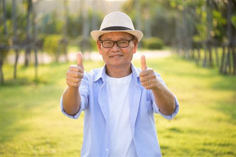 A Happy Old Man With Thumbs Up Smiling And Laughing In The Garden