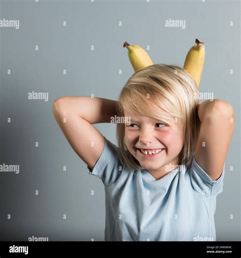 Retrato De Niño Con Las Manos Detrás De La Cabeza Sujetando Las Bananas Fotografía De Stock Alamy