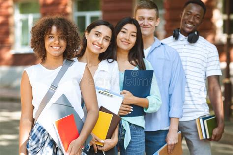 Group Of International Students Posing Near College Building Smiling