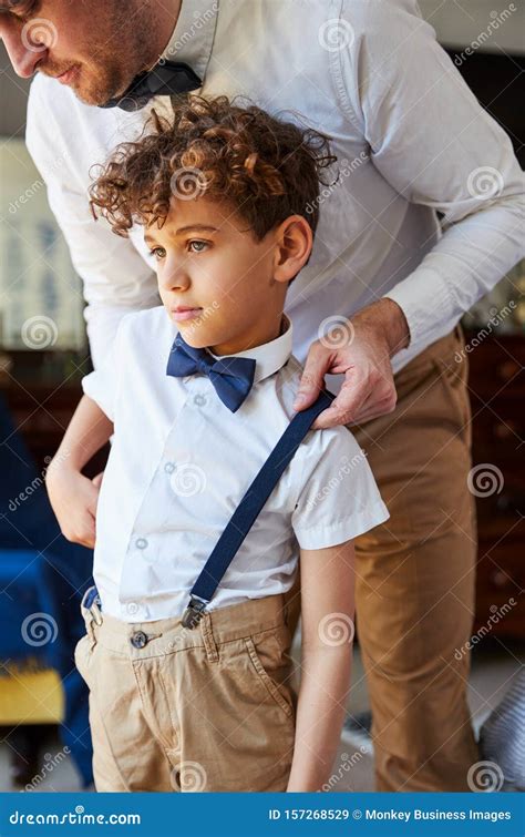 Father And Son Wearing Matching Outfits Getting Ready For Wedding At Home Royalty Free Stock
