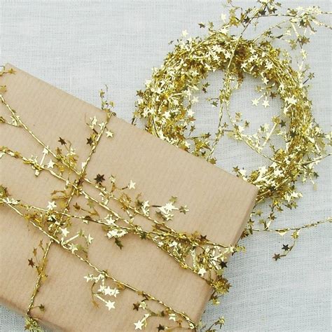 Some come adorned with christmas ornaments, bows and other festive flair. twinkling gold star garland by just add a dress | notonthehighstreet.com