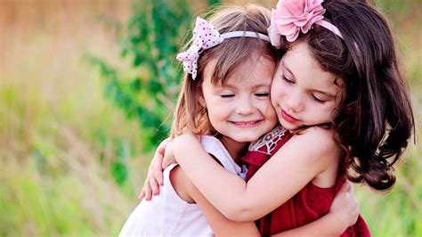 Cute Two Little Girls Are Hugging Each Other Wearing Red And White