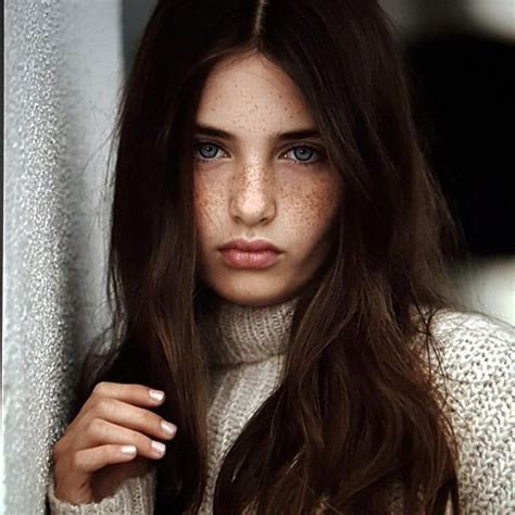 A Woman With Freckled Hair And Blue Eyes Wearing A Turtle Neck Sweater