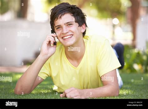 Teenage Boy Laying In Park Using Mobile Phone Stock Photo Alamy