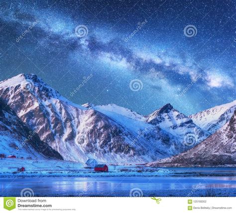 Milky Way Above Houses And Snow Covered Mountains In Winter Stock Photo