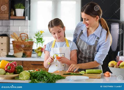 Mother Teaching Child To Cook And Help In The Kitchen Stock Photo