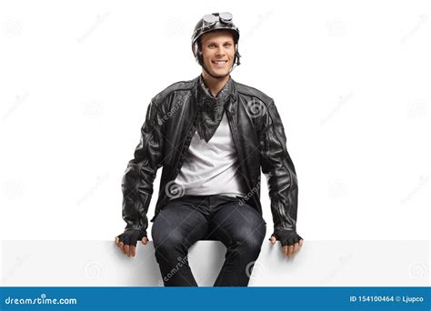 Young Guy Biker Sitting On A Panel And Looking At The Camera Stock