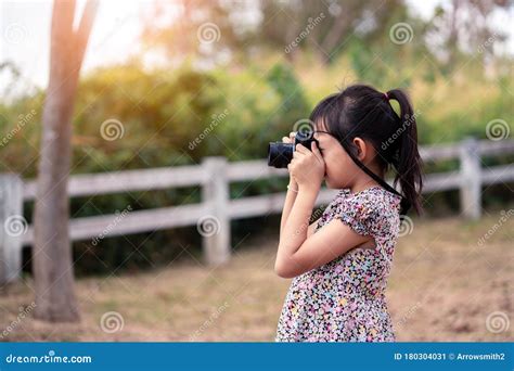 Asian Little Child Girl Holding Film Camera And Taking Photo With Of