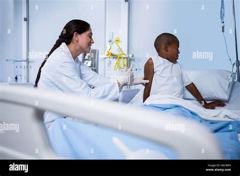 Female Doctor Giving An Injection To Patient In Ward Stock Photo Alamy