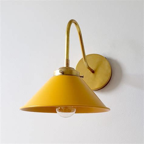 Shop with afterpay on eligible items. Mustard and Brass modern wall sconce with a curved arm and ...