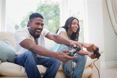 Happy couple on the couch playing video games | Bookmans Entertainment