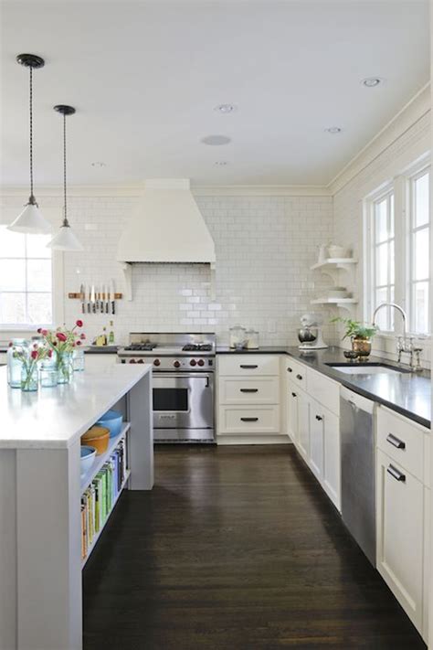 The white cabinets contrast with black countertops, and they would look off if it weren't of the mid tones. Black and white kitchen design with white shaker cabinets ...