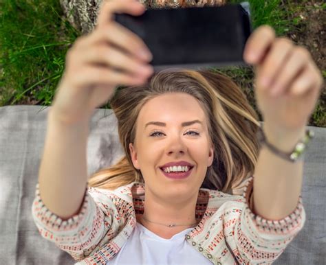 Premium Photo Portrait Of Happy Woman Lying In Grass Taking Selfie With Smart Phone Beautiful