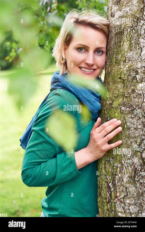 Woman Leaning Against A Tree Stock Photo Alamy