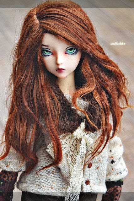 a doll with long red hair and green eyes