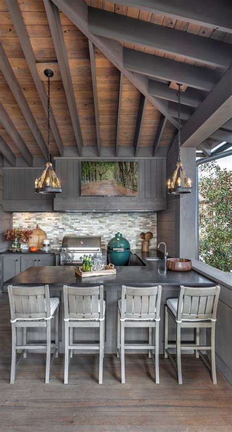 An Outdoor Kitchen With Wooden Floors And Gray Cabinets Along With