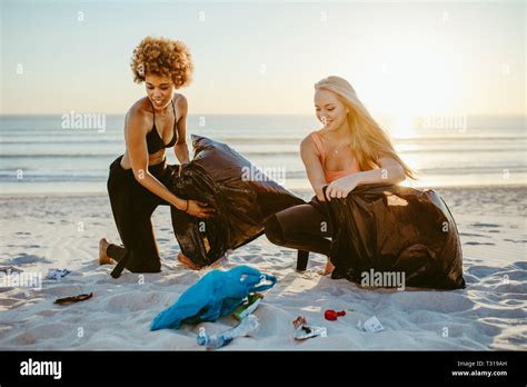 Los jóvenes voluntarios recogiendo basura en la playa en bolsas de