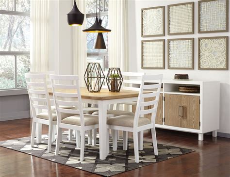 Blue floral curtains hang from dining room windows and accent blue grasscloth walls lined white wainscoting. Gardomi White and Light Brown Rectangular Dining Room Set from Ashley | Coleman Furniture