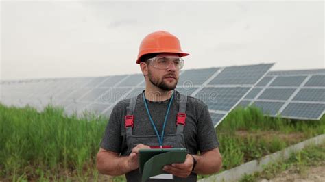 Man Engineer In Uniform Hold Digital Tablet And Working Near Solar