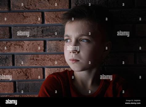 Sad Little Boy Near Brick Wall Domestic Violence Concept Stock Photo