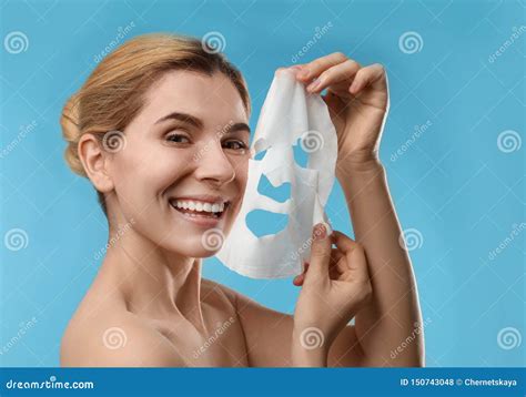 belle femme avec la feuille faciale de masque de coton photo stock image du modèle bleu