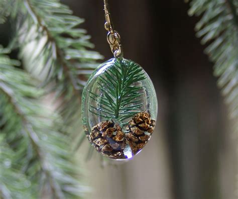 A simple way to do that is by covering the flowers and leaves with a layer of clear drying glue. Pine Tree Resin Pendant | Resin jewelry, Diy resin ...