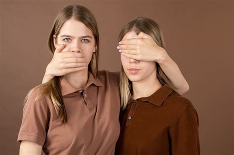 Premium Photo One Of Twins Covering Mouth Of Another Girl Keeping