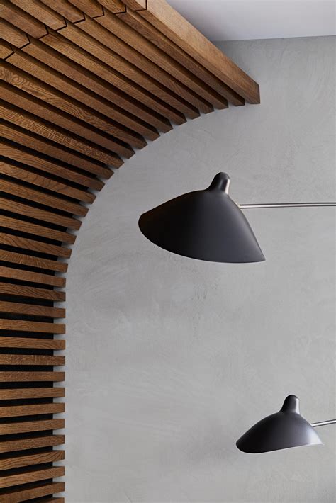 A Curved Wood Slat Accent Wall Spans The Living Room And Dining Area Of