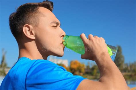 Young Sporty Man Drinking Water From Bottle Outdoors Stock Photo