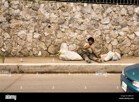 Guatemala City Guatemala Central America Homeless Man Sitting On The Side Of The Road Stock