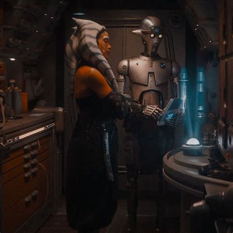Two People Standing In A Kitchen Next To Each Other With Robot Heads On