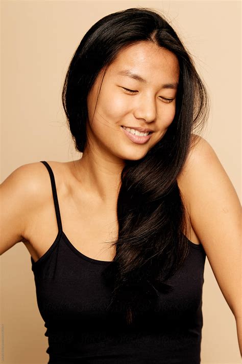 Young Beautiful Asian Woman Portrait Smiling With Eyes Closed Isolated