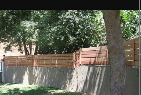 Concrete formed retaining wall with fence on top #FenceDiy | Wooden