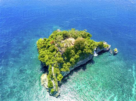 Indonesia. Emerald ocean water. A small rocky island, overgrown with 