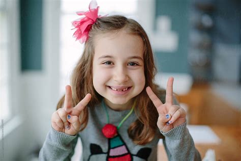 Cute Young Girl Showing The Peace Sign With Her Hands By Jakob