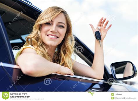 An Attractive Woman In A Car Holds A Car Key In Her Hand Stock Photo