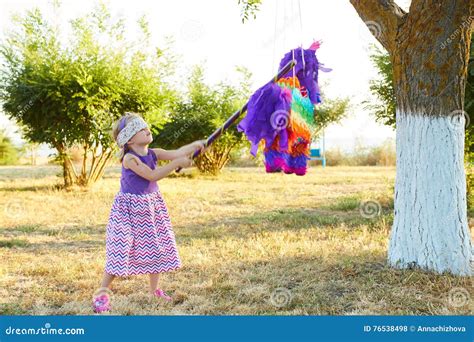 Young Girl At An Outdoor Party Hitting A Pinata Stock Photo Image Of
