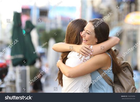 Happy Meeting Of Two Friends Hugging In The Street Stock Photo