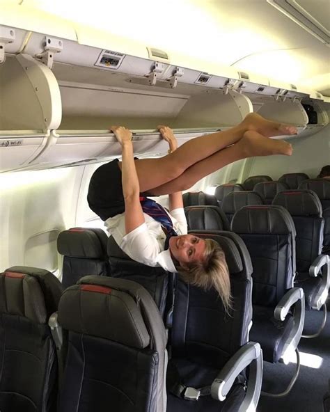 A Woman Is Hanging Upside Down On An Airplane With Her Legs Spread Out And One Leg In The Air