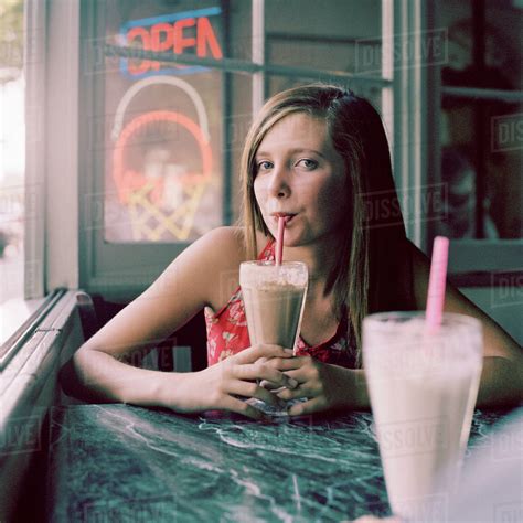 A Teenage Girl Drinking A Milkshake In A Diner Stock Photo Dissolve
