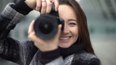 Beautiful Young Female Photographer Taking Pictures Puts The Focus