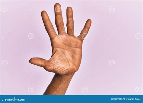 Arm And Hand Of Black Middle Age Woman Over Pink Isolated Background