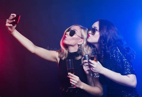 Close Up Shot Of Group Of Laughing Women Wearing Black Dresses Having Party Take Selfie With