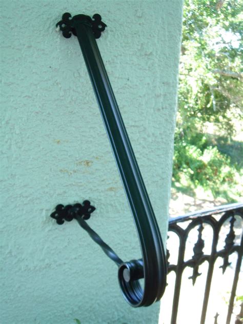 A Black Wrought Iron Door Handle On A White Stucco Wall