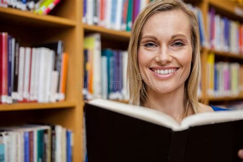 Happy Female Student Reading A Book In The Library Stock Image Image